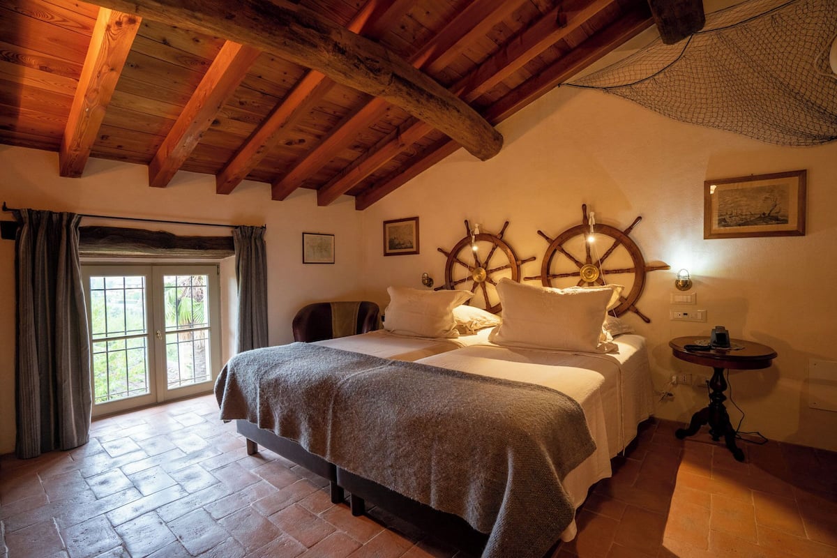 Une pièce confortable avec un lit, un bureau et une fenêtre avec des rideaux.