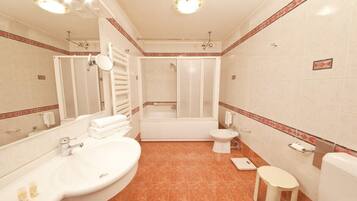 A bathroom with a bathtub, toilet, sink, and a mirror.