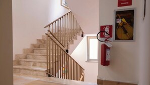 Eine Treppe mit hölzernen Geländern und einem an der Wand befestigten Feuerlöscher.