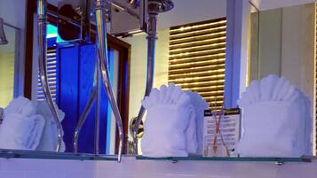 Une salle de bain moderne avec un lavabo blanc, des robinetteries chromées et un miroir au-dessus.