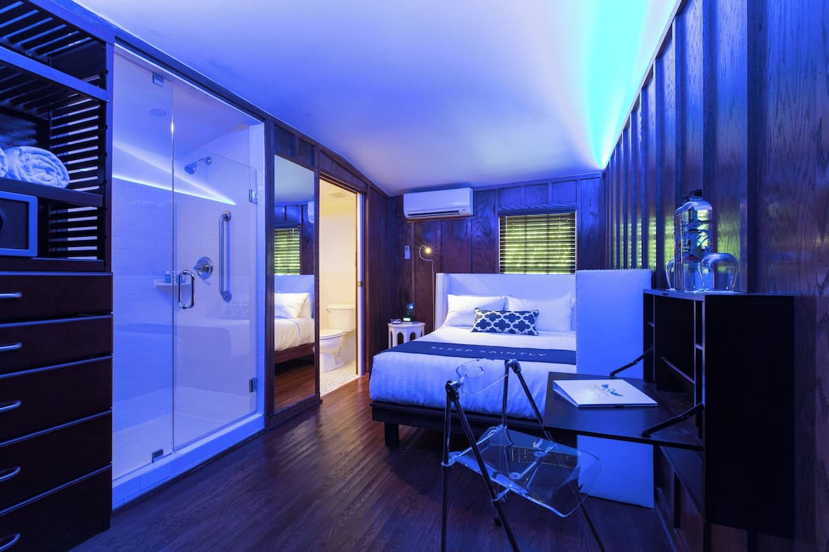 A modern bedroom with a bed, bedside table, and a walk-in closet.