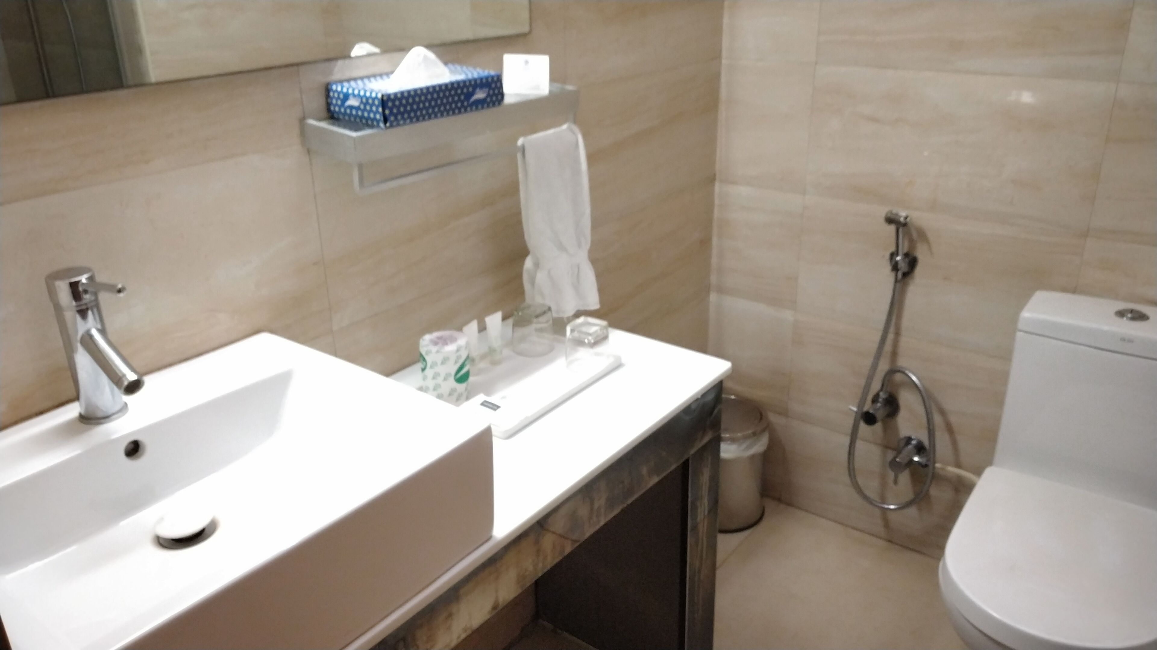 Een badkamer met een wastafel, spiegel, toilet en douche.