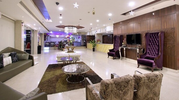 A spacious lobby with a sofa, armchairs, a coffee table, and a reception desk. - Best Western Ashoka (Hyderabad)