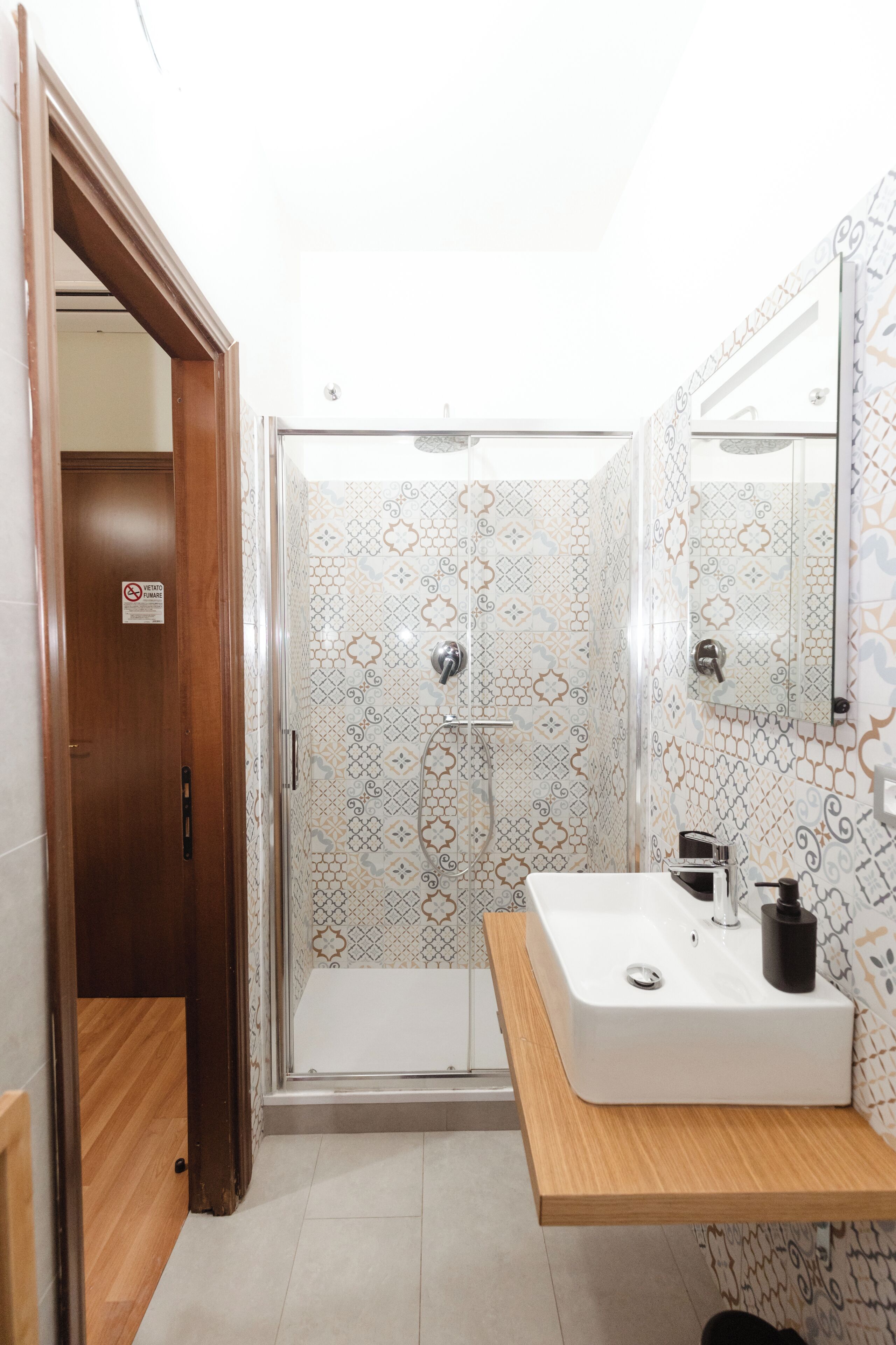 A bathroom with a shower, a sink, and a mirror.