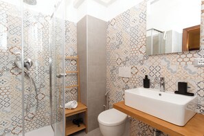 Driepersoonskamer | Badkamer | Een douche, gratis toiletartikelen, een haardroger, een bidet