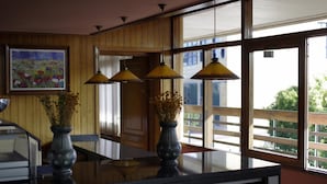 A kitchen with wooden paneling, a large window, and three pendant lights. - Hotel Los Olivos (Getafe)
