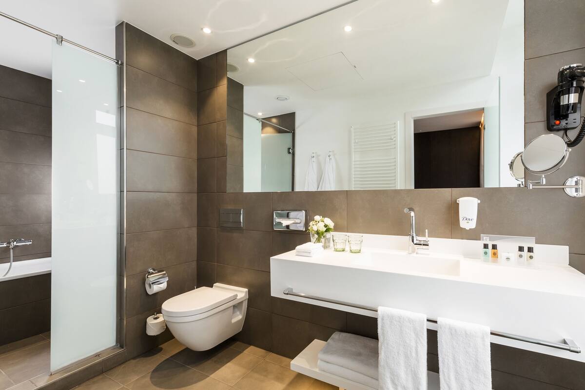 A modern bathroom with a shower, toilet, and vanity.