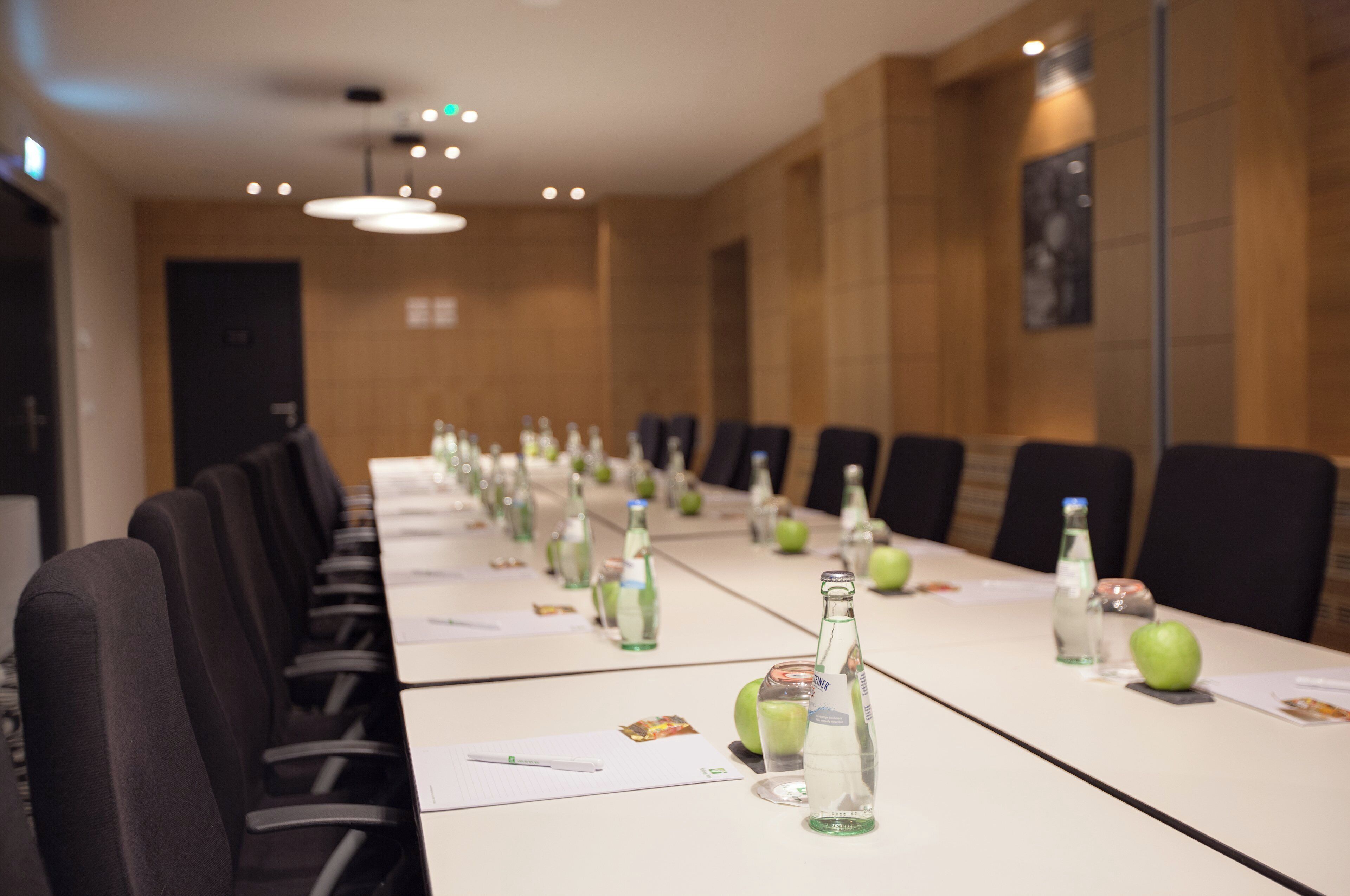 A conference room with a long table, chairs, and bottles of water.