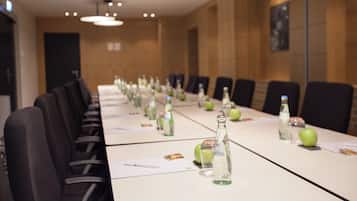A conference room with a long table, chairs, and bottles of water.