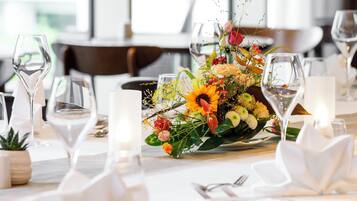 A table set for dining with a centerpiece of flowers and candles.