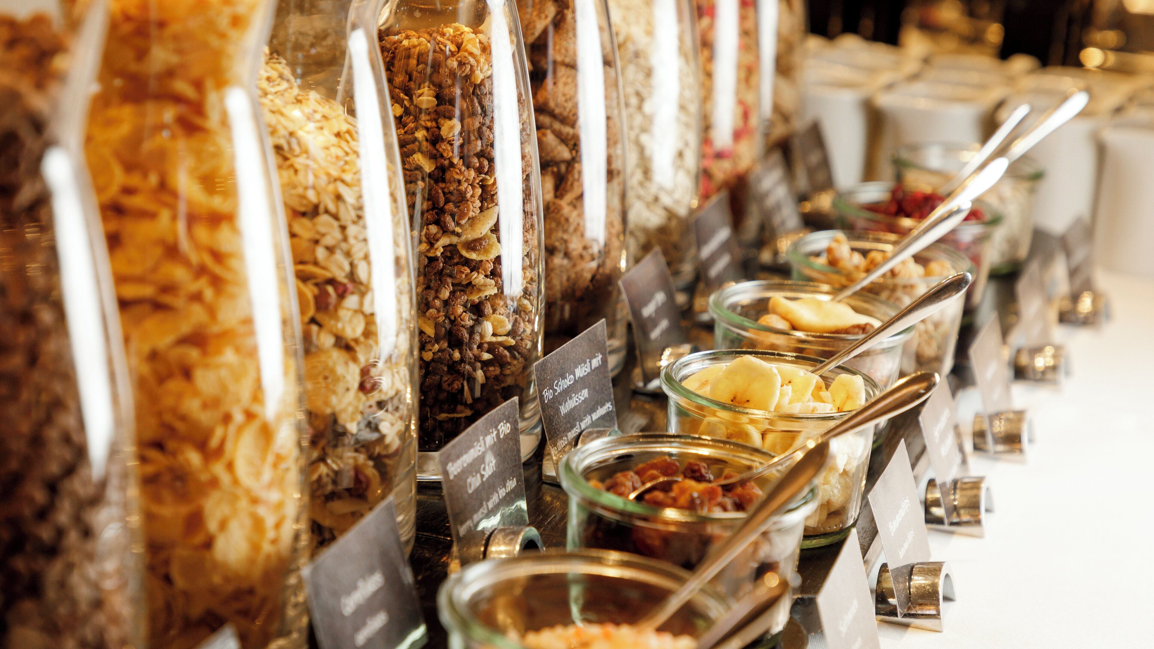 A buffet with various food options, including granola, yogurt, and fruit.