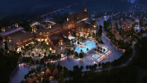 A resort with multiple buildings, a central pool, and surrounding palm trees. - Sheraton Grand Xishuangbanna Hotel (Xishuangbanna Dai)