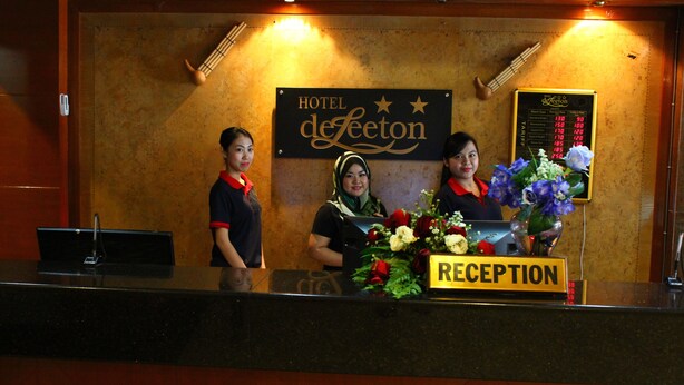 A reception desk at Hotel de Leeton with a sign indicating the reception area. - Hotel DeLeeton (Kota Kinabalu)