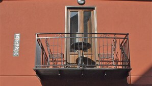 A building with a balcony, a door, and two potted plants. - B&B Porta delle Madonie (Campofelice di Roccella)