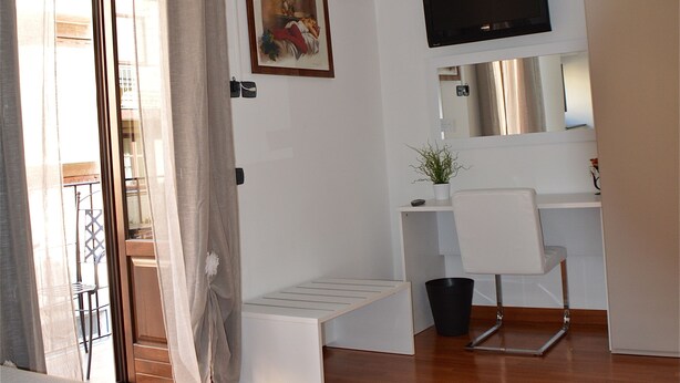 A modern bedroom with a bed, a desk, a chair, a television, and a ceiling fan. - B&B Porta delle Madonie (Campofelice di Roccella)