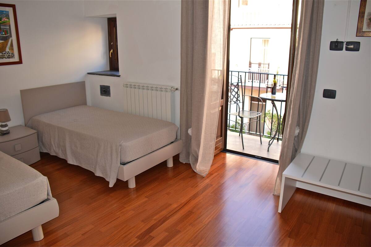 A bedroom with a bed, bedside table, and a bench.