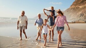 A family walking on a beach with a clear sky and mountains in the background. - Rosedene Guest House (Cape Town)