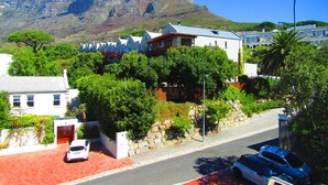 A residential area with houses, a prominent mountain in the background, and a street with parked cars. - Rosedene Guest House (Cape Town)