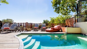 A pool area with lounge chairs and a wooden deck. - Rosedene Guest House (Cape Town)