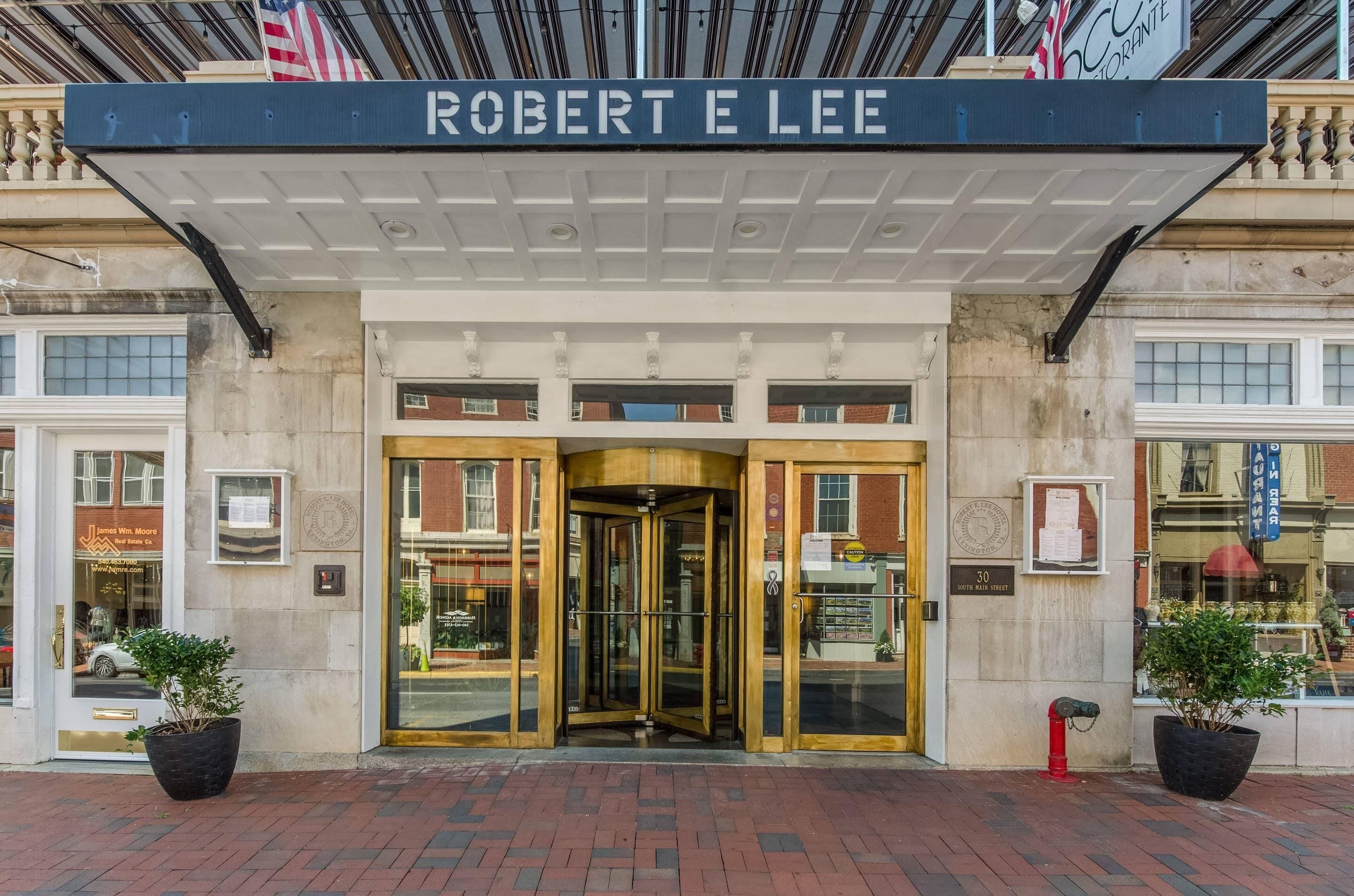 The entrance of the Robert E Lee hotel with a revolving door and a sign above.