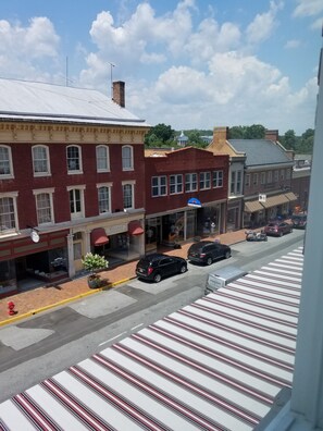A street view with a row of brick buildings, a crosswalk, and parked cars. - The Gin Hotel, an Ascend Collection Hotel (Lexington)