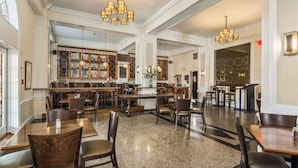 A spacious restaurant with high ceilings, chandeliers, and a bar area with shelves of bottles. - The Gin Hotel, an Ascend Collection Hotel (Lexington)