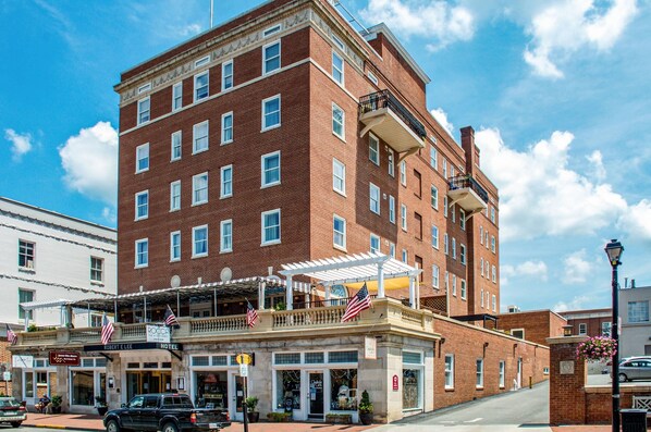 A brick building with a balcony and American flags, featuring a sign for 'Robert E. Lee Hotel'. - The Gin Hotel, an Ascend Collection Hotel (Lexington)