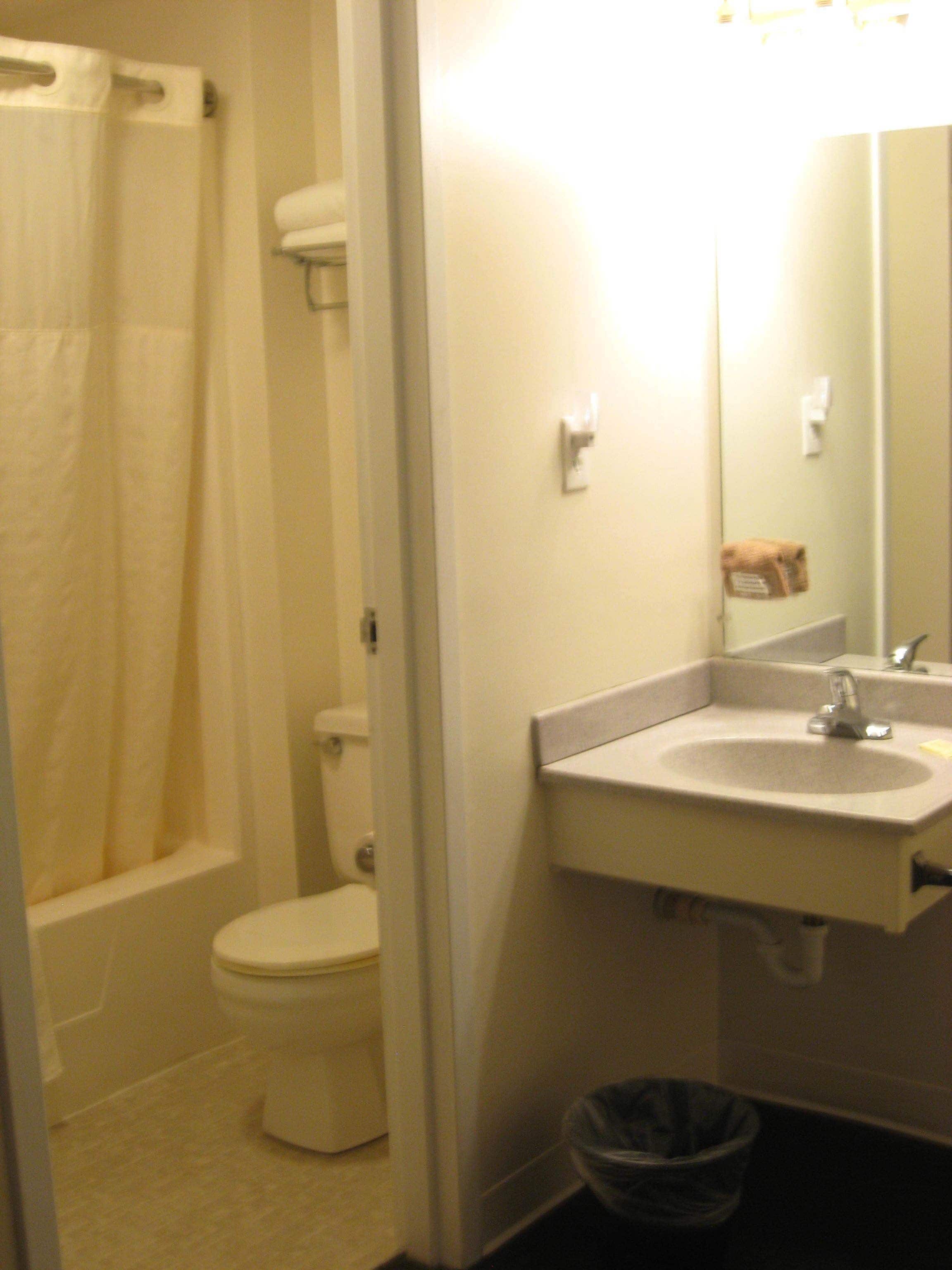 Un baño con inodoro, lavamanos y cortina de ducha.