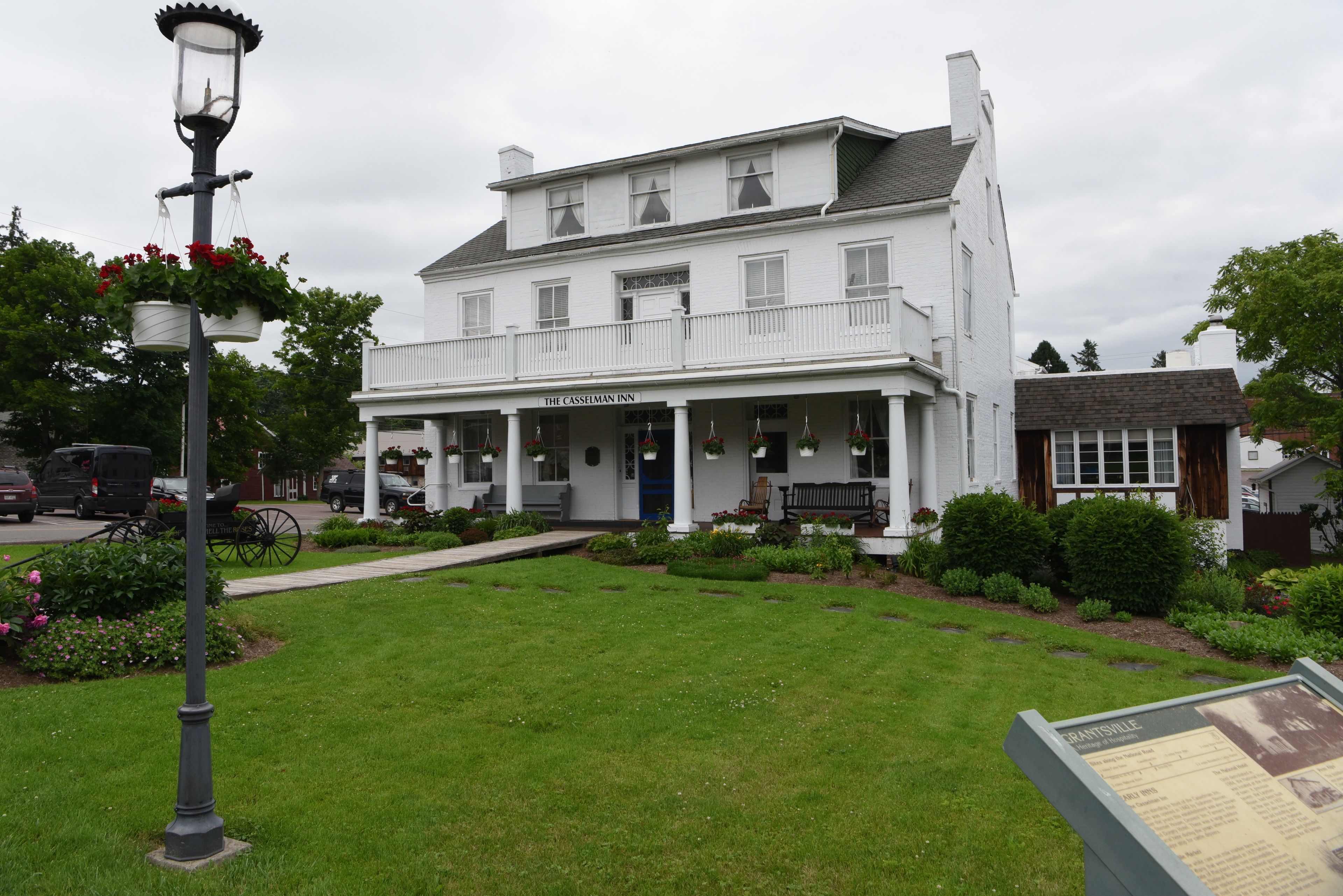En vit byggnad med en veranda och en skylt med texten ”The Casselman Inn”.
