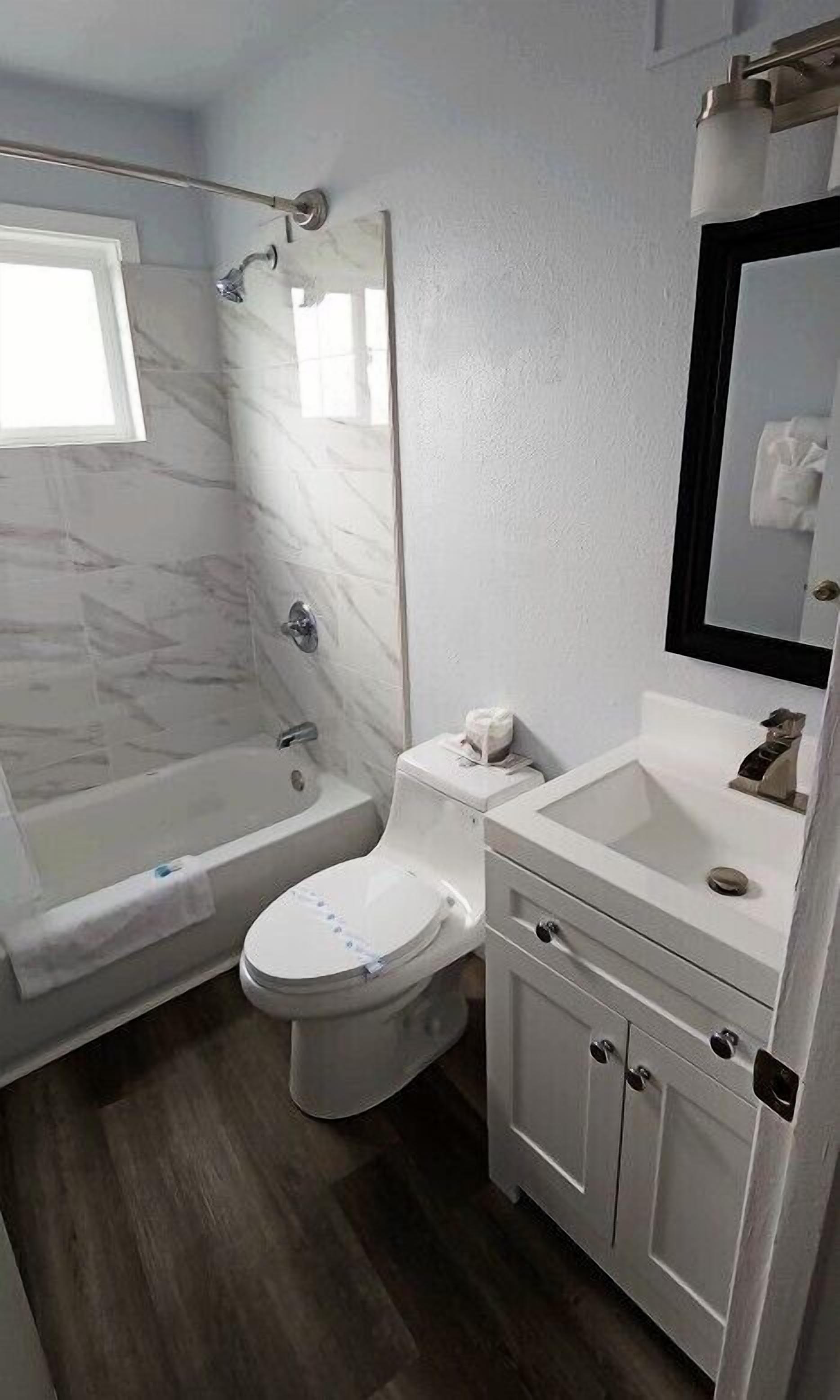 A bathroom with a shower, toilet, and sink.