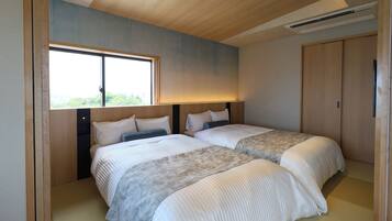 Une chambre d’hôtel moderne avec deux lits, une grande fenêtre et un plafond en bois.