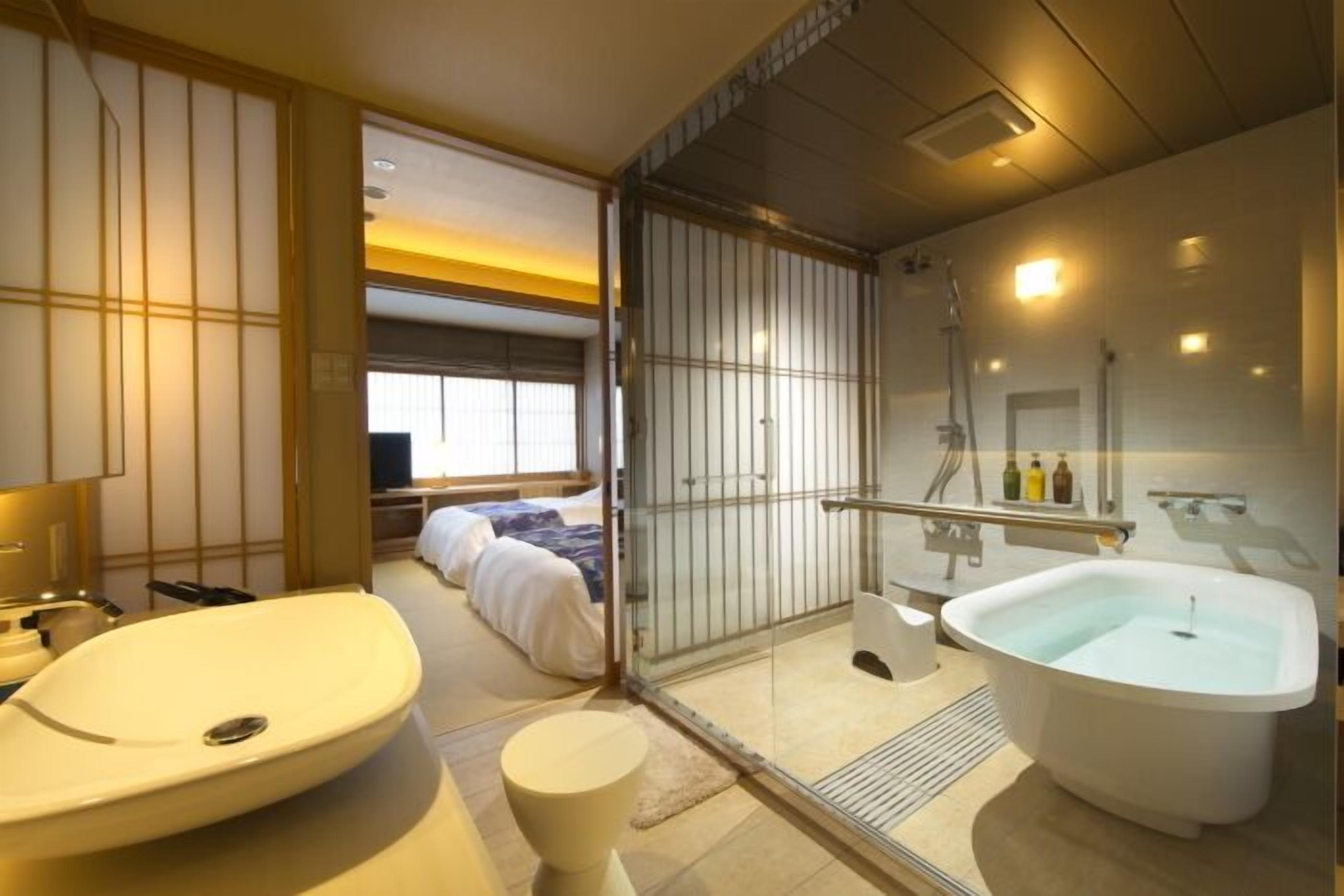 A modern bathroom with a large bathtub, a separate shower area, and a toilet.