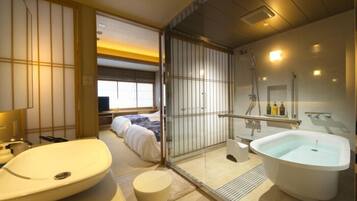 A modern bathroom with a large bathtub, a separate shower area, and a toilet.