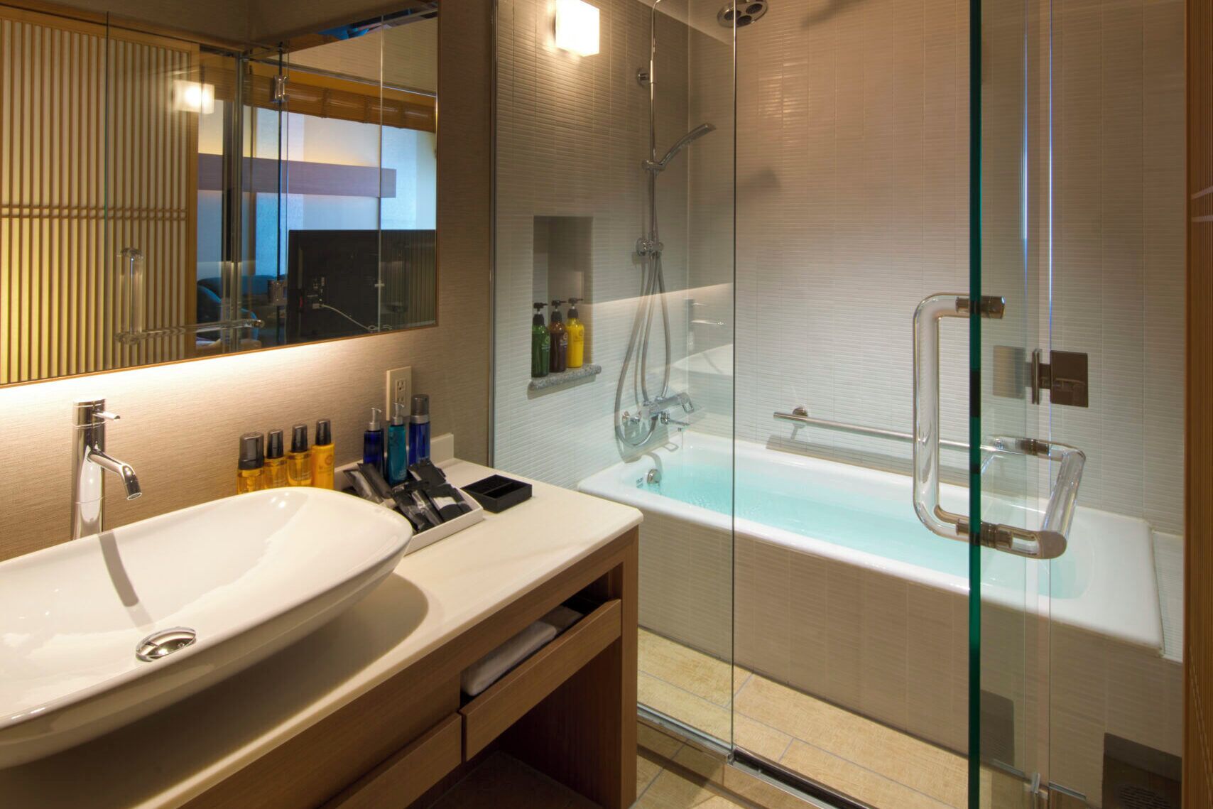Un baño moderno con un lavamanos grande, cabina de ducha con mampara de vidrio y una bañera.