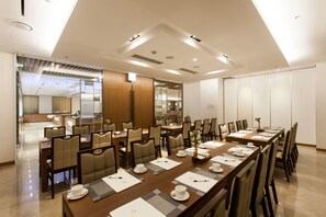 A conference room with a long table set for a meeting, surrounded by chairs, and a separate dining area with tables and chairs. - Migliore Hotel Seoul Myeongdong (Seoul)