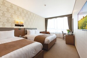 A hotel room with two beds, a desk, a chair, a nightstand, a lamp, and a painting on the wall. - Migliore Hotel Seoul Myeongdong (Seoul)