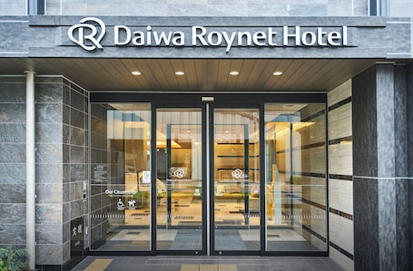 The Daiwa Roynet Hotel entrance with glass doors and a sign above.