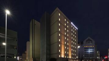 A Daiwa Roynet Hotel with multiple floors, a modern architectural design, and illuminated windows.