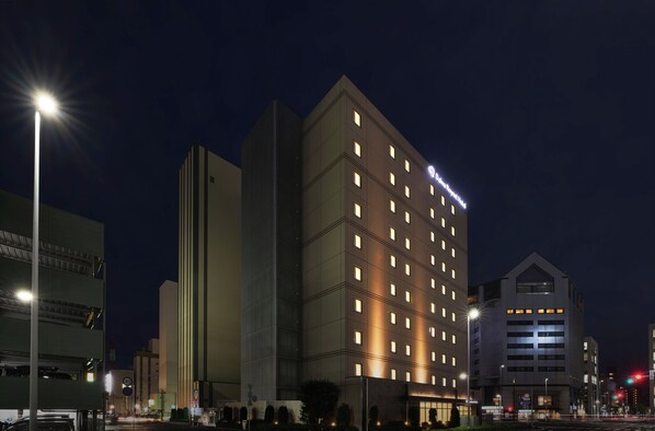 Un hotel Daiwa Roynet con varios pisos, diseño arquitectónico moderno y ventanas iluminadas.