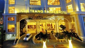 Een hotel met meerdere verdiepingen, een opvallende ingang en verlichte ramen.