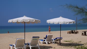 På stranden, vit sandstrand, solstolar och parasoller