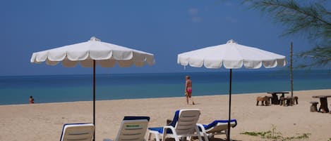 Plage, sable blanc, chaises longues, parasols