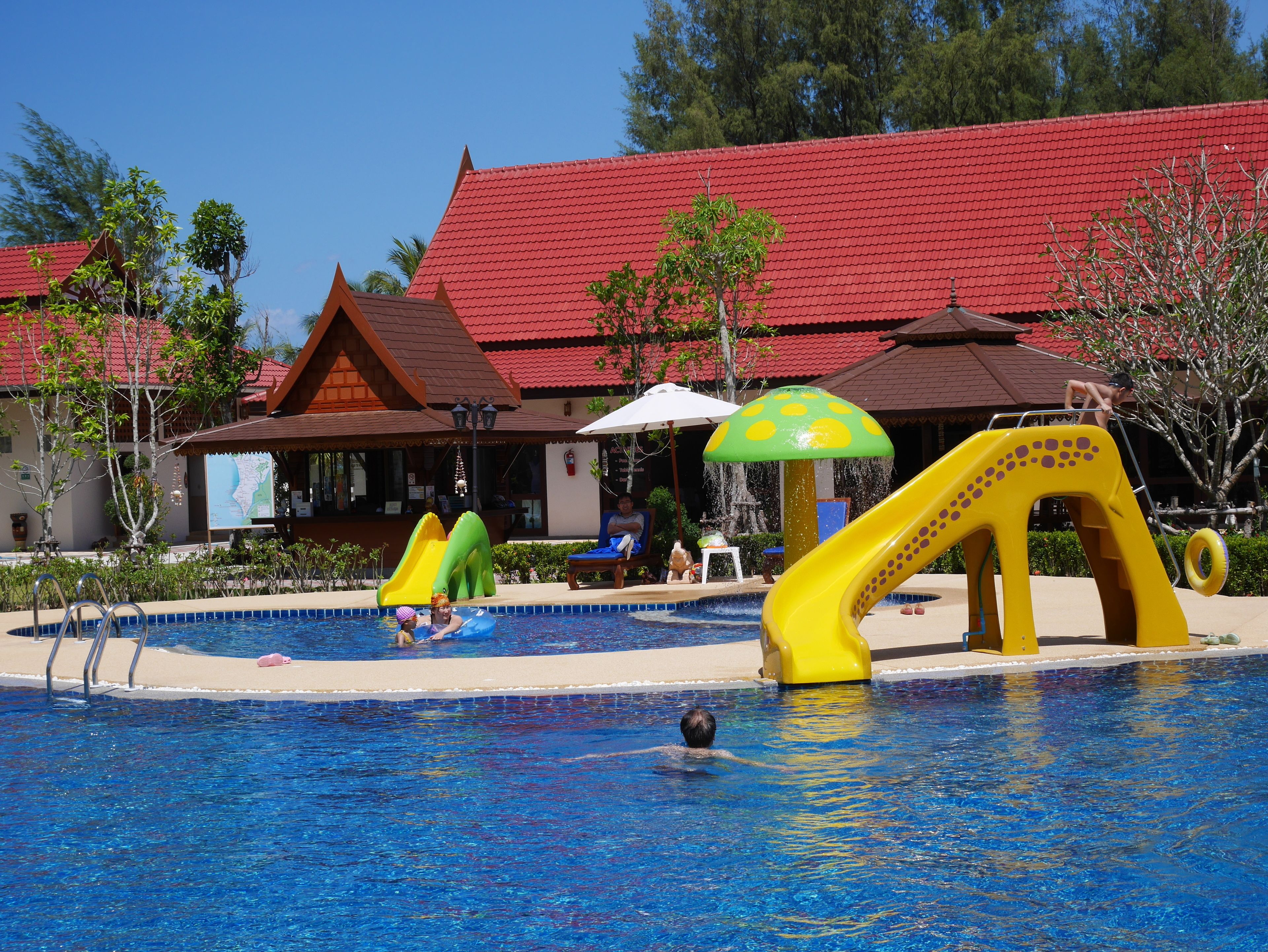 Une piscine avec un toboggan et un espace de jeux aquatiques.