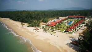 A resort with a beach, a pool, and a forested area.