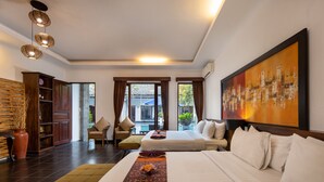 A hotel room with two beds, a large painting, a sofa, and a view of the outside. - Ubud Raya Boutique Hotel (Ubud)