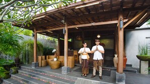 A covered entrance with steps leading up to a building, surrounded by greenery and potted plants. - Ubud Raya Boutique Hotel (Ubud)