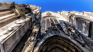 A detailed view of a building's ornate architectural features, including a large arched window and intricate stone carvings. - Hotel Saint Maurice (Lille)