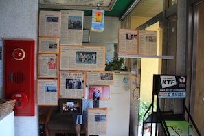 Una pared con varios carteles informativos y una caja roja de alarma contra incendios.