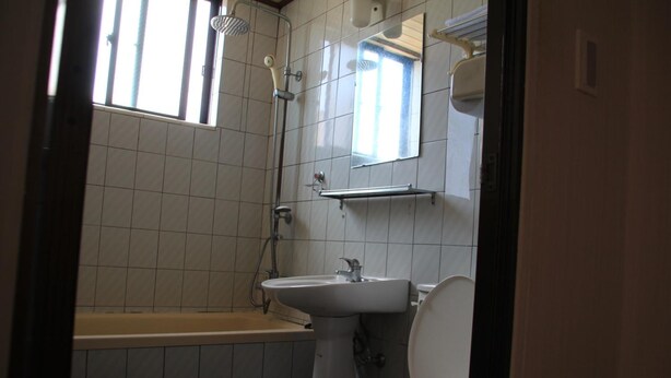 A bathroom with a bathtub, a sink, and a toilet. - Minjoonggak Guesthouse (Seogwipo)