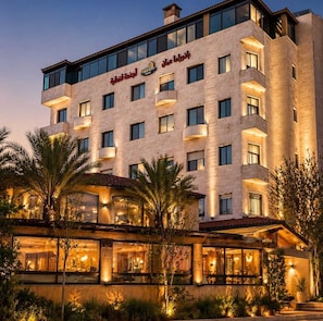 Ein mehrstöckiges Hotel mit modernem Design, mit Balkonen und großen Fenstern.